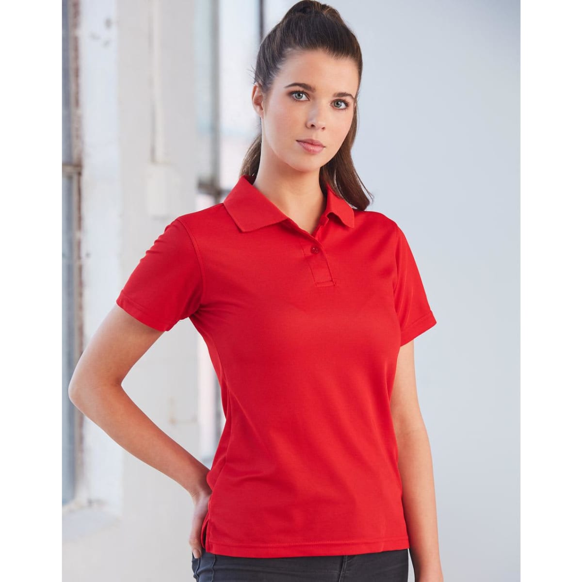 A red short-sleeved polo shirt for ladies, featuring a classic collar and a branding logo.