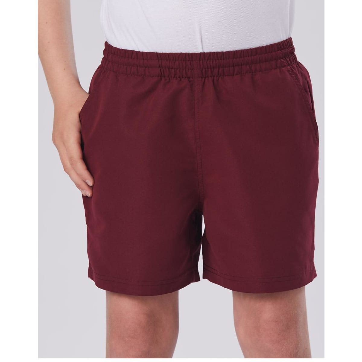 Kids microfibre sports shorts in a deep burgundy colour, featuring an elastic waistband and side pockets.