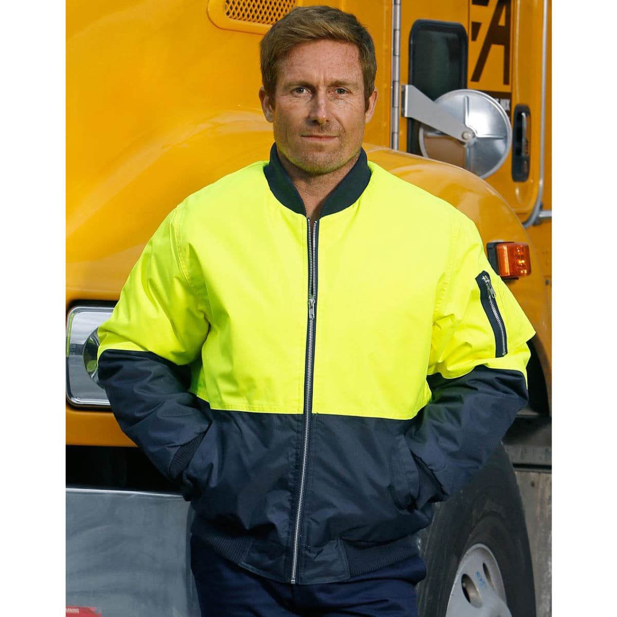 A Hi-Vis two-tone flying jacket in bright yellow and navy, featuring a zipped front and pockets, worn by a man.