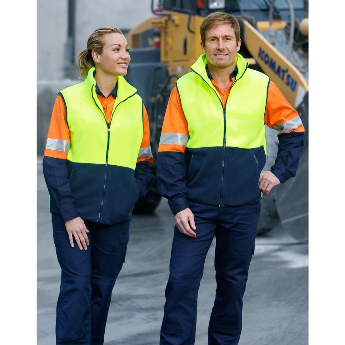 Hi-Vis two-tone polar fleecy vests in bright yellow and navy, worn by a man and woman, featuring reflective stripes.