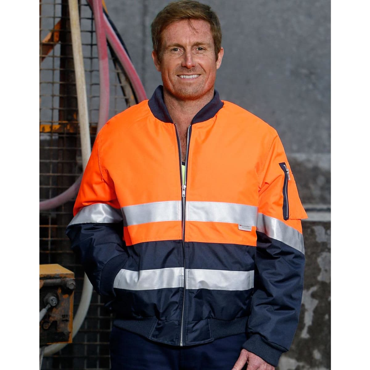 A Hi-Vis two-tone jacket in orange and navy, featuring reflective 3M tapes and a zip closure. It has a logo on the sleeve.