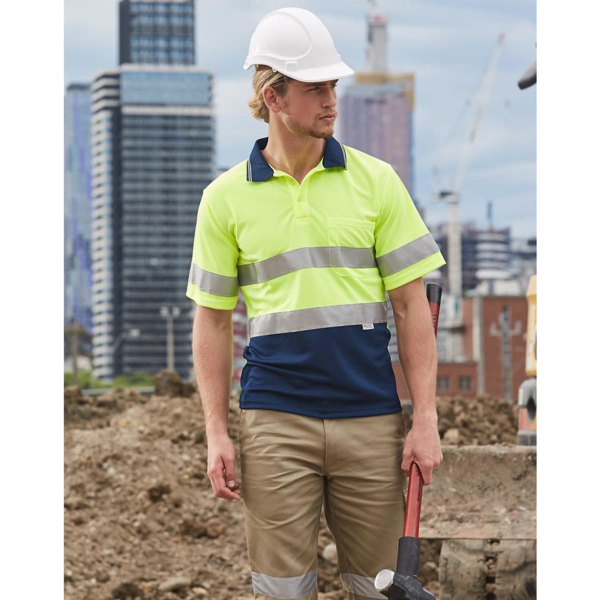 A hi-vis yellow and navy safety polo shirt featuring reflective 3M tape, worn by a male construction worker.