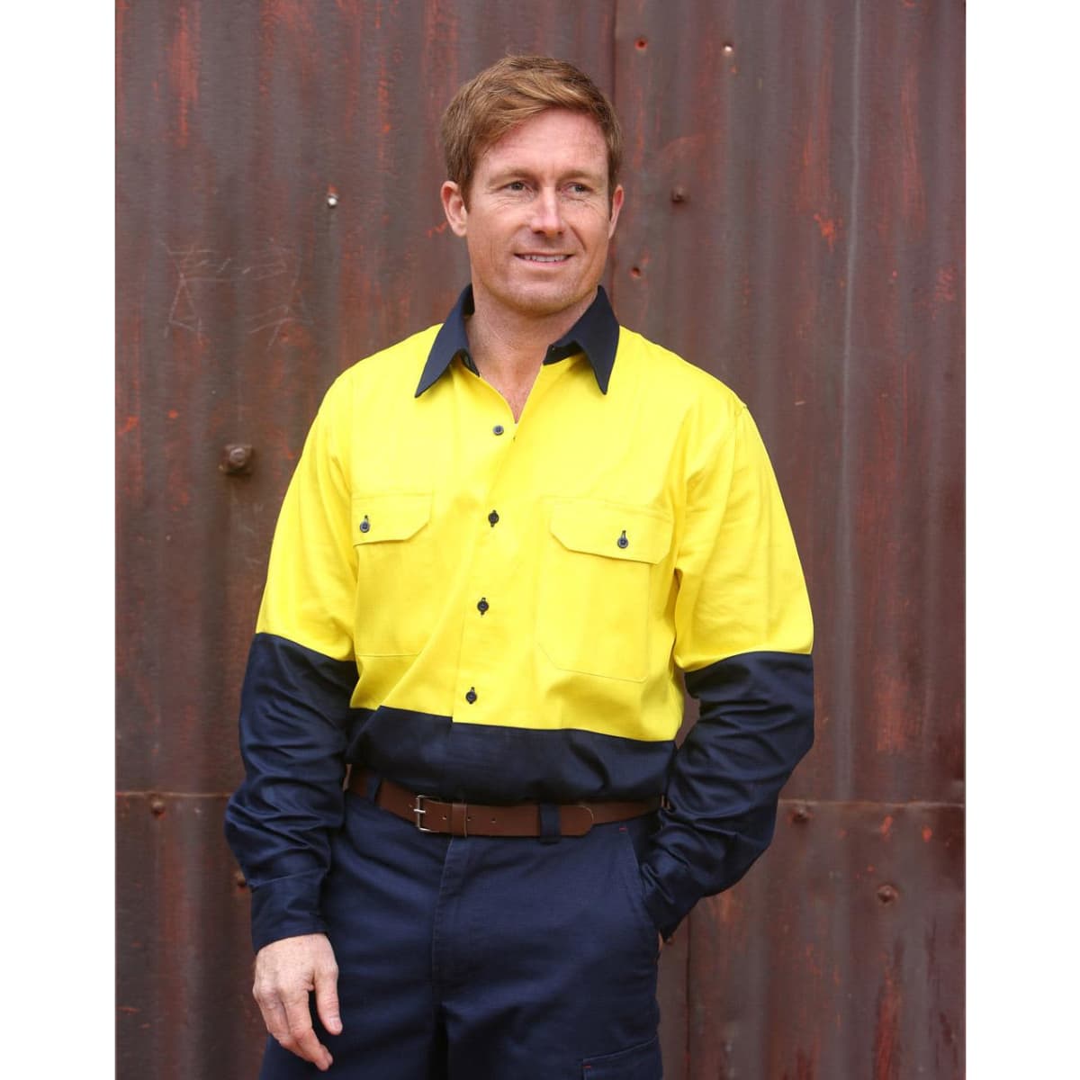 A long-sleeve, high-visibility shirt in yellow and navy blue with a logo, featuring two chest pockets.