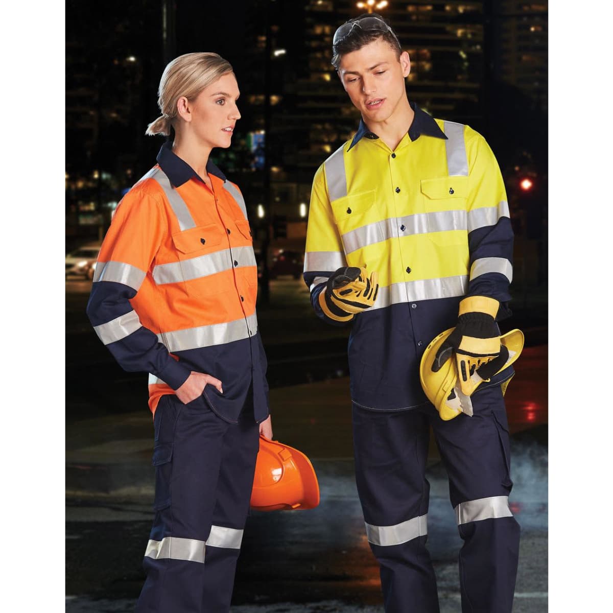 Two workers wearing two-tone safety shirts in orange and yellow, featuring reflective tape, with hard hats and gloves.