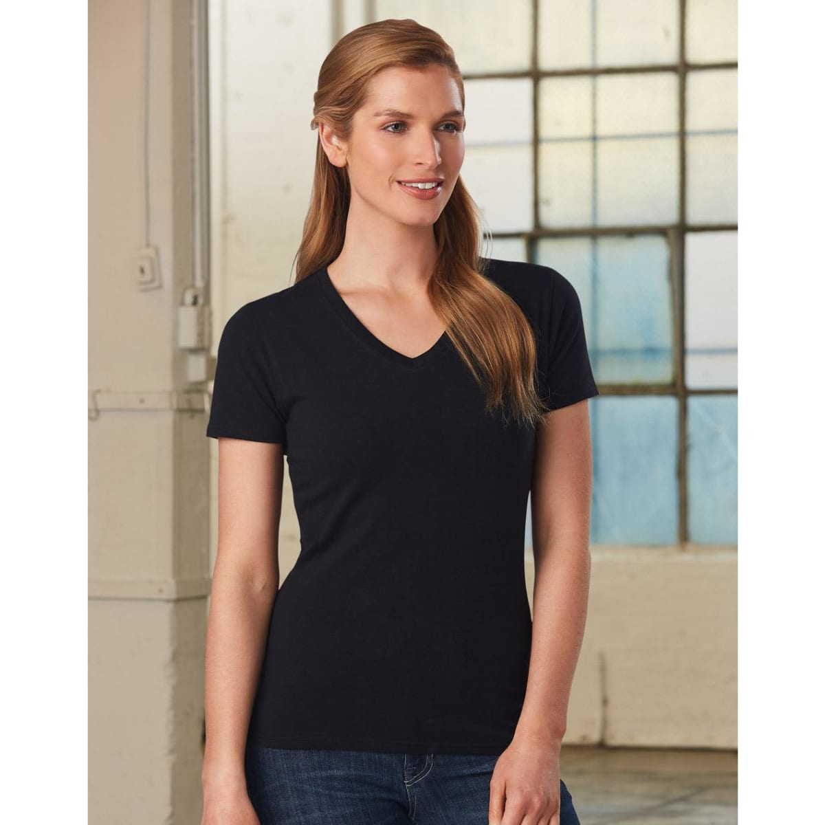 A black ladies' V-neck short-sleeve tee, featuring a fitted style and a logo. The model is smiling in a bright setting.