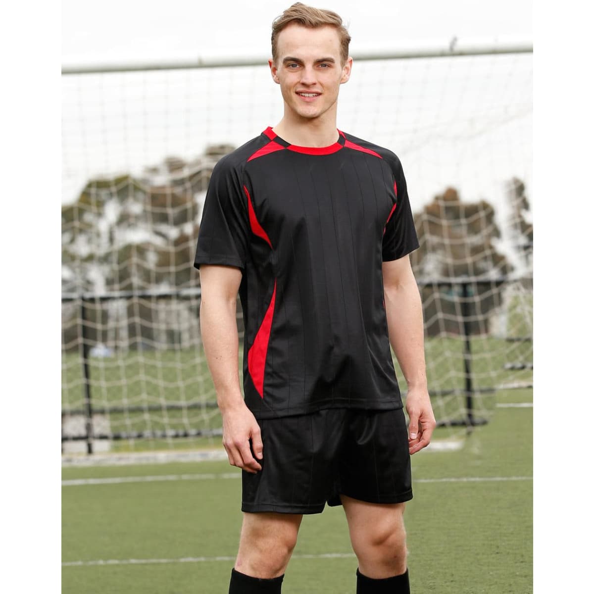 A black adults' soccer jersey with red accents, featuring short sleeves and a sporty design, displayed on a model.