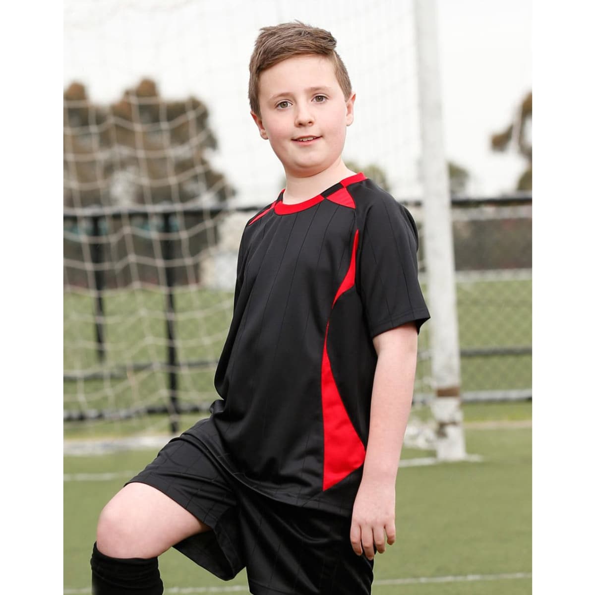 A kid's soccer jersey featuring black with red accents, designed for sports uniforms. It includes a logo.
