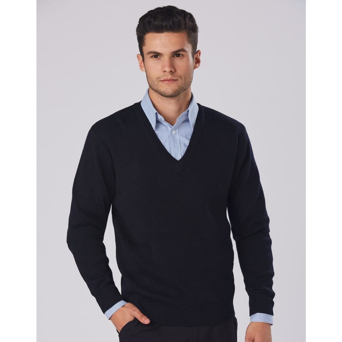 A black V-neck wool and acrylic knit jumper worn over a blue collared shirt, featuring a branding logo.