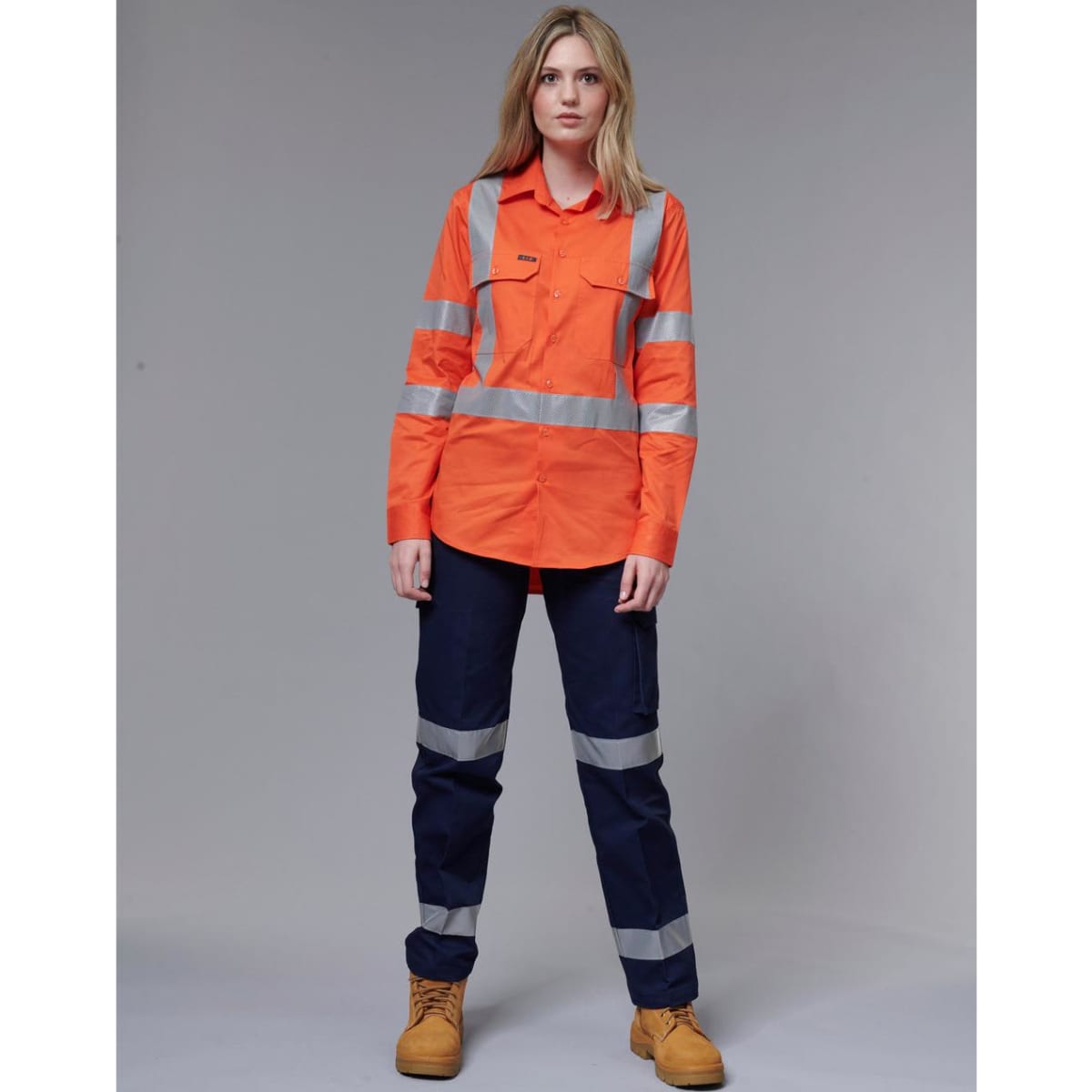 Ladies' heavy cotton drill pants in navy with 3M reflective tape. Model wears a matching high-visibility orange shirt.