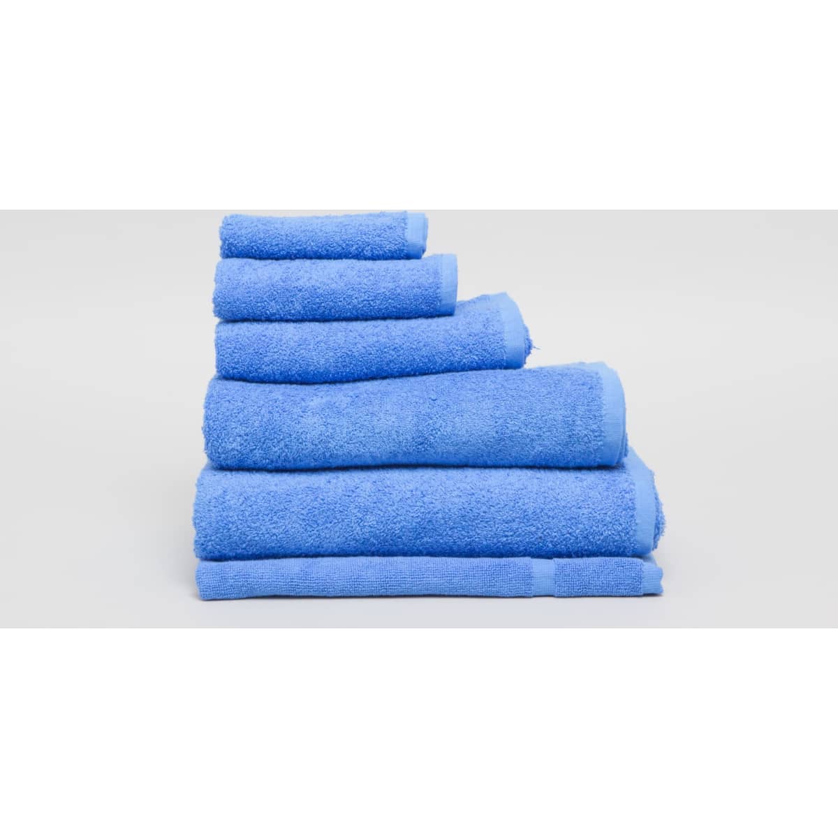 A stack of light blue towels in varying sizes, featuring a soft, textured surface. The image includes a logo.