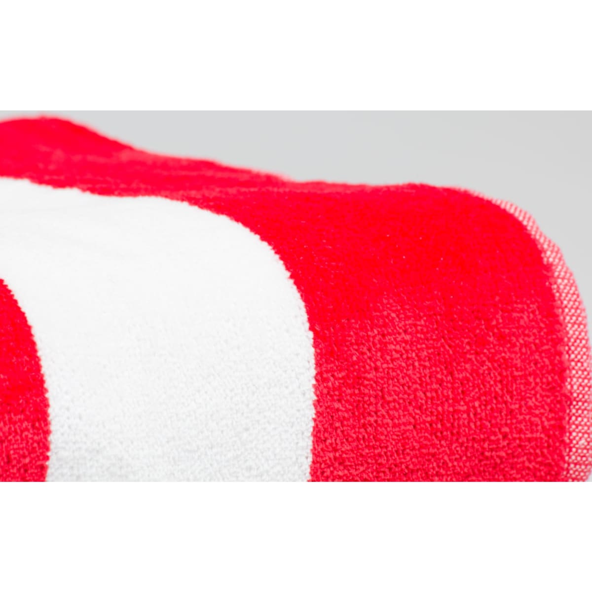 A textured red towel with a white stripe, showcasing vibrant colours and a soft finish. It features a logo in the corner.
