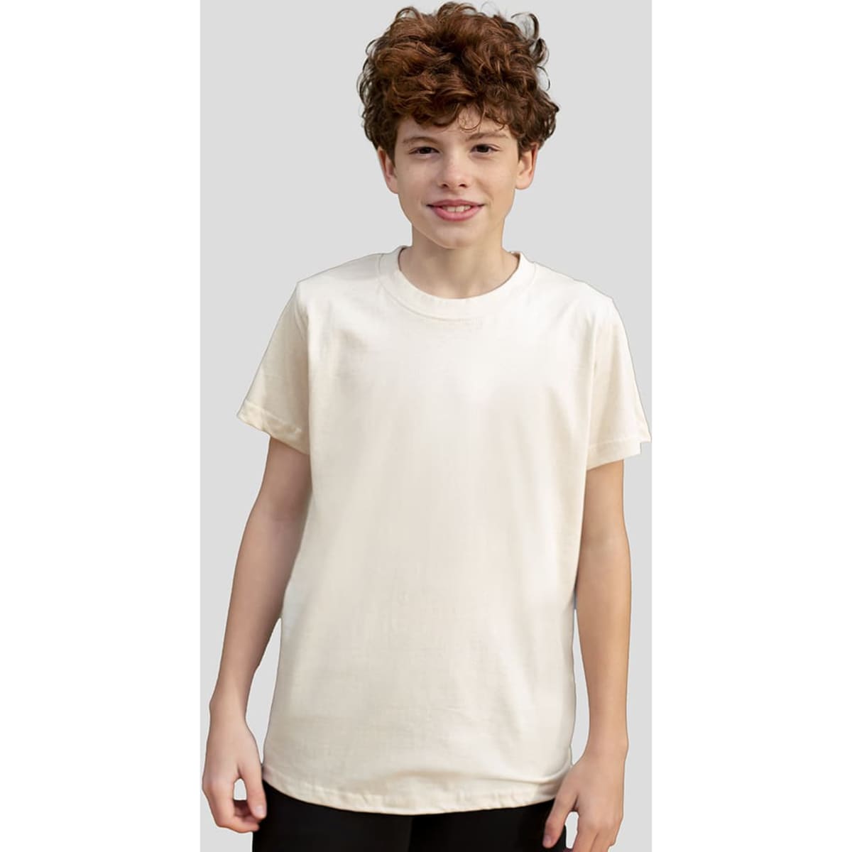 A plain cream organic T-shirt displayed on a smiling young individual. The shirt has short sleeves and a relaxed fit.