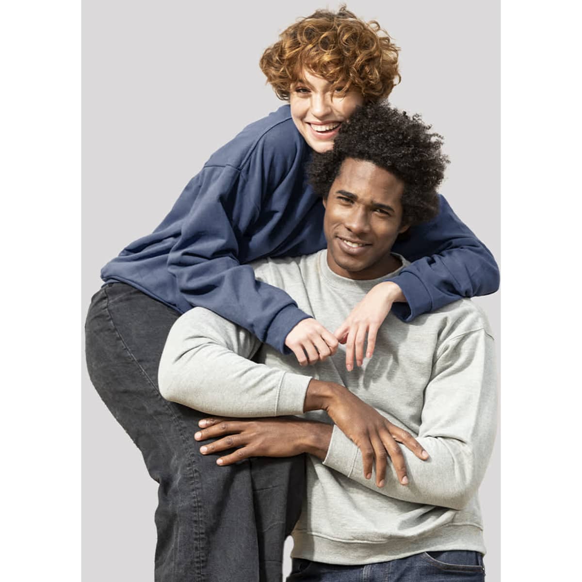 A grey hoodie worn by a man and a navy hoodie worn by a woman, both smiling and posing together.