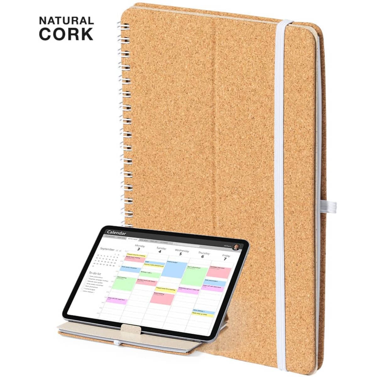 A cork notebook with a wire spiral binding, featuring an elastic band, next to a tablet displaying a calendar.