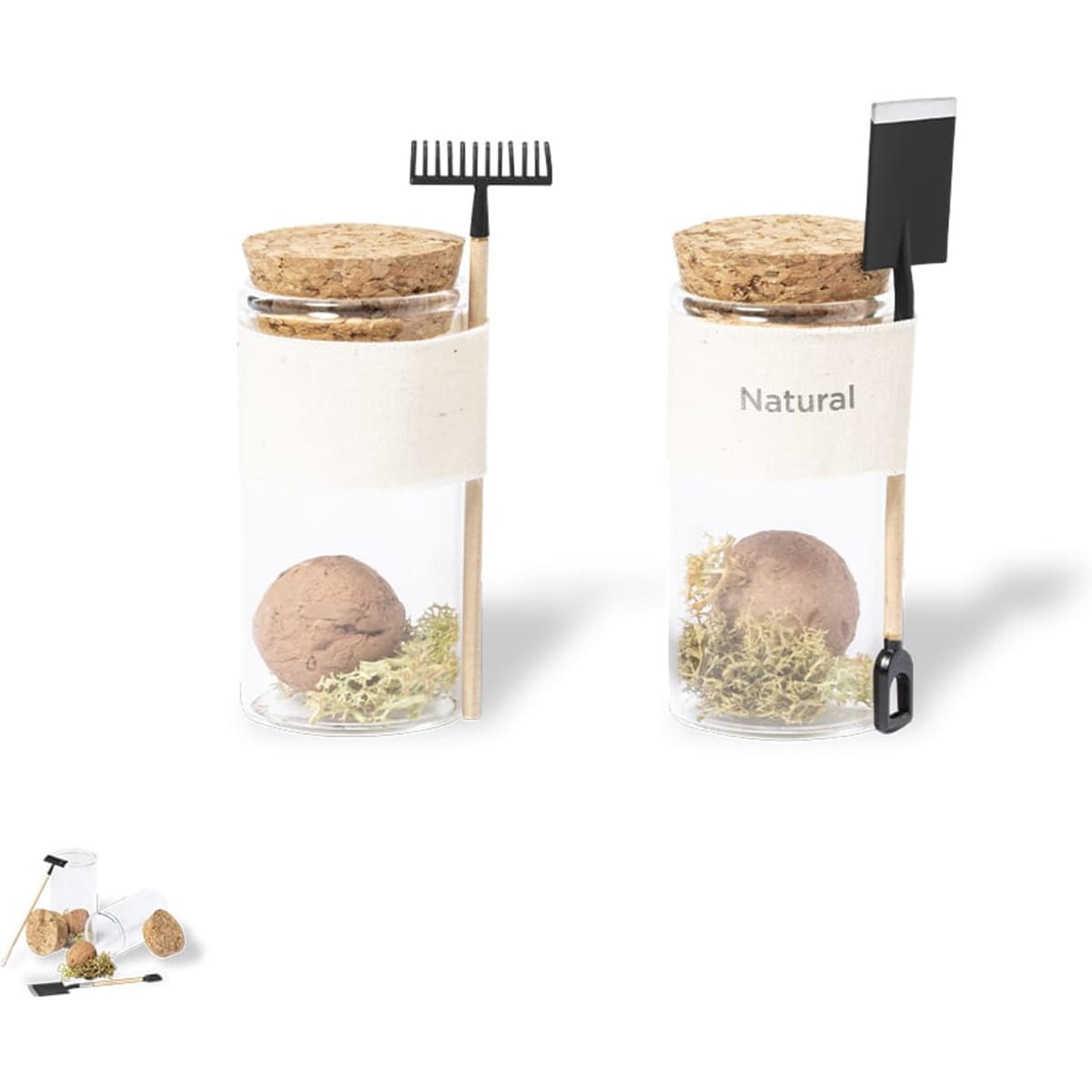 A glass jar with a cork lid, containing seed bombs and decorative moss, with a small rake and spade attached.