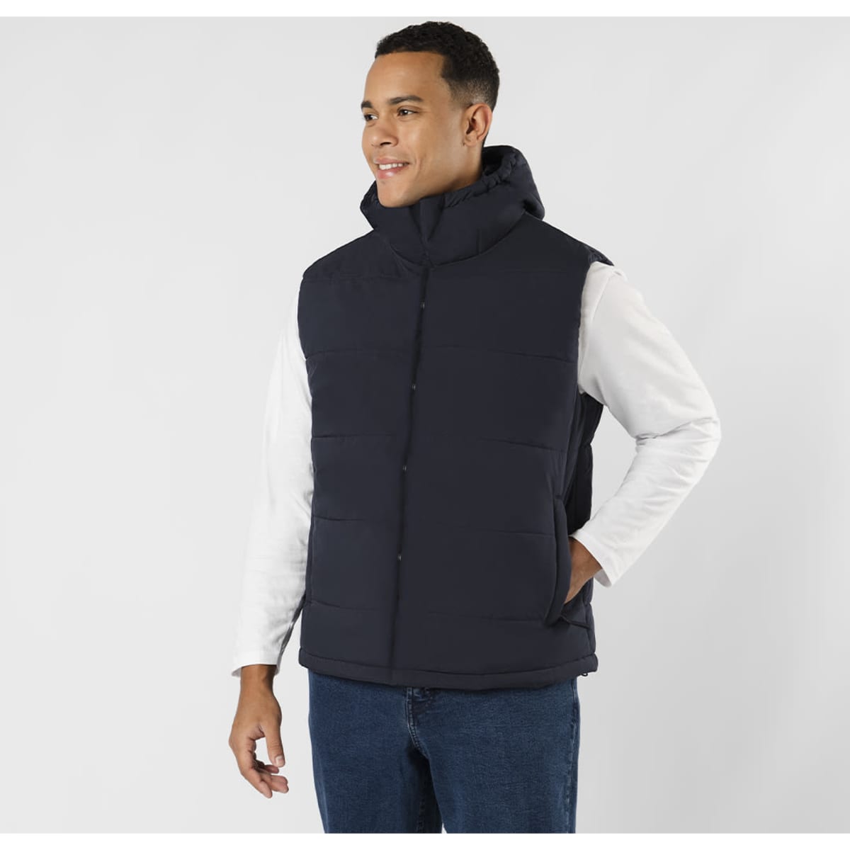 A navy puffer vest with a hood, featuring pockets and a zip-up front, worn by a smiling man.