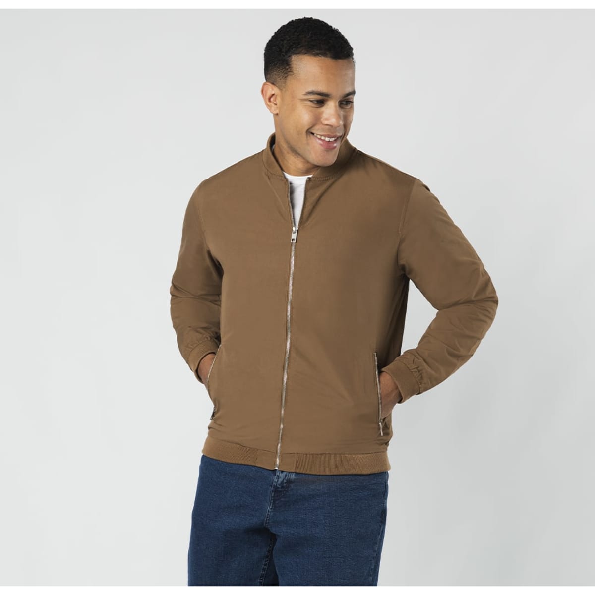 A brown jacket with a zip front, featuring a stand-up collar and two front pockets. The model is smiling while wearing it.