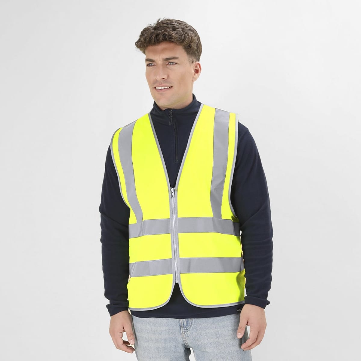 A high-visibility yellow safety vest with reflective stripes, worn by a smiling male model.