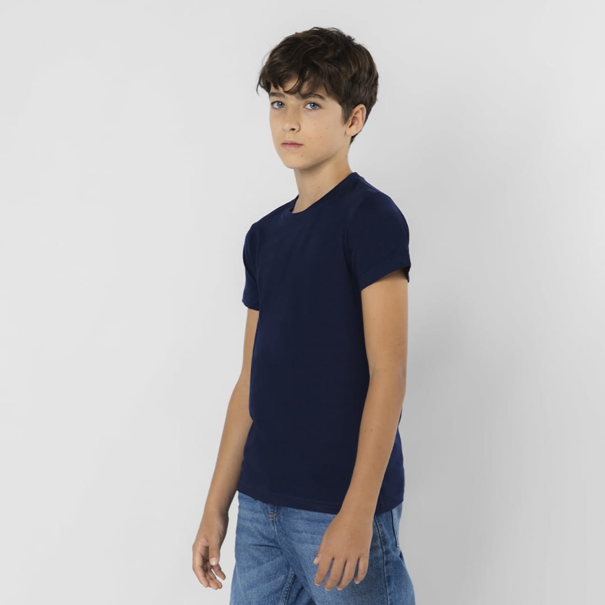 A navy blue T-shirt on a young model, featuring a round neckline and short sleeves. The model is wearing jeans.