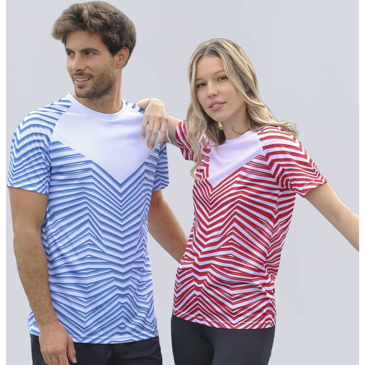 A blue and white zigzag patterned T-shirt worn by a man, and a red and white zigzag patterned T-shirt worn by a woman.