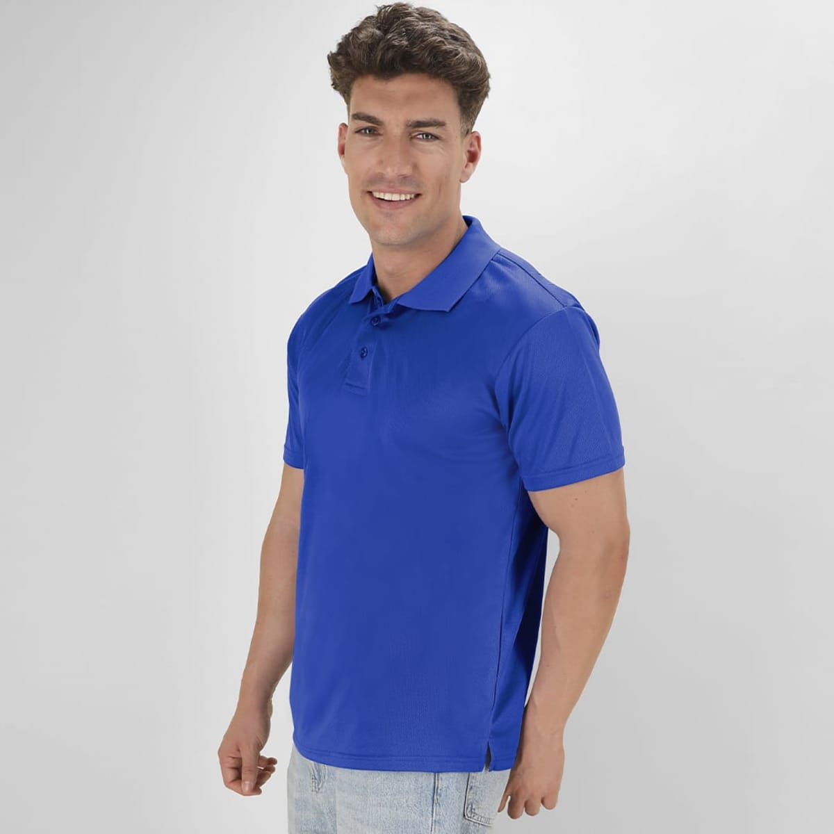 A blue polo shirt with a collar and short sleeves, featuring a logo. The model is smiling and wearing light jeans.