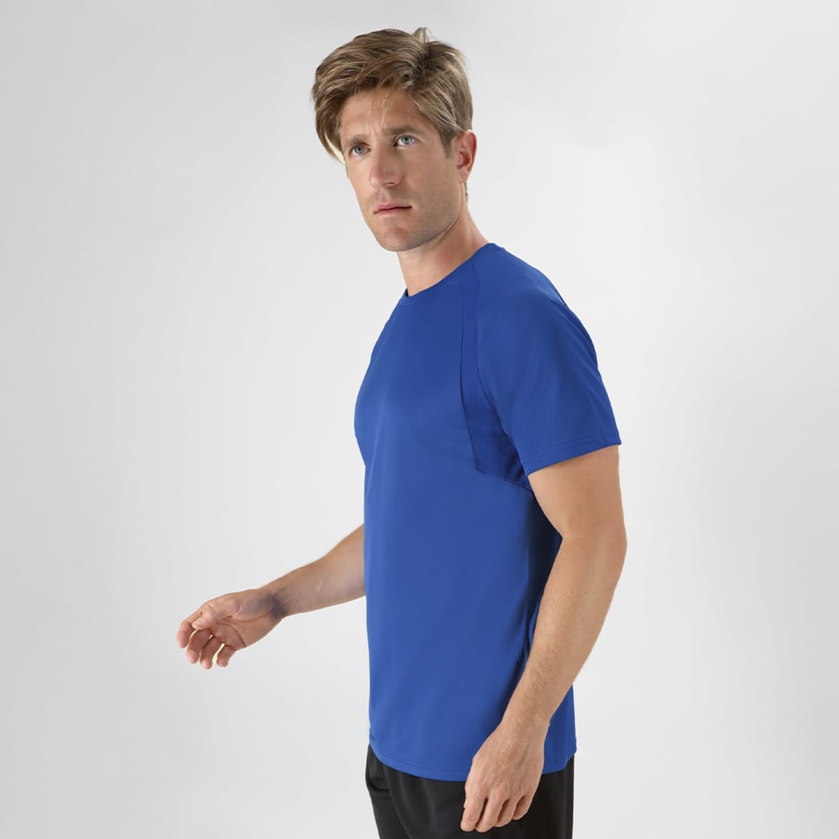 A blue t-shirt displayed on a model standing sideways, with a simple design and no visible logos.