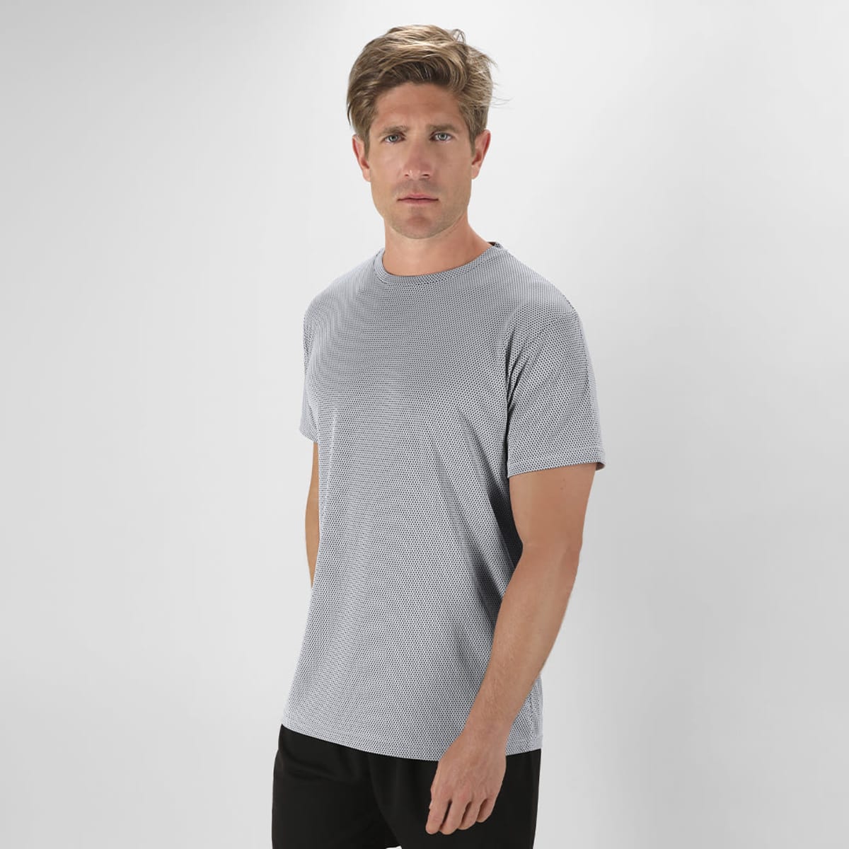 A grey T-shirt worn by a model, featuring a simple design and short sleeves. The shirt has a logo on it.