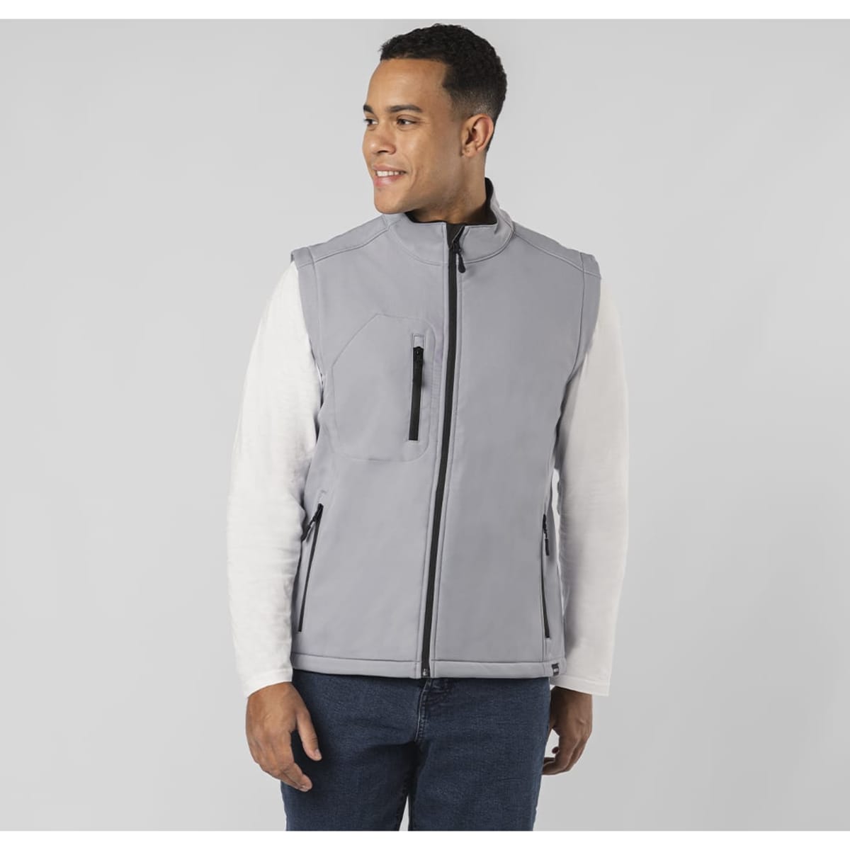A grey soft shell jacket features a zip front, side pockets, and a chest pocket, worn by a man against a plain background.