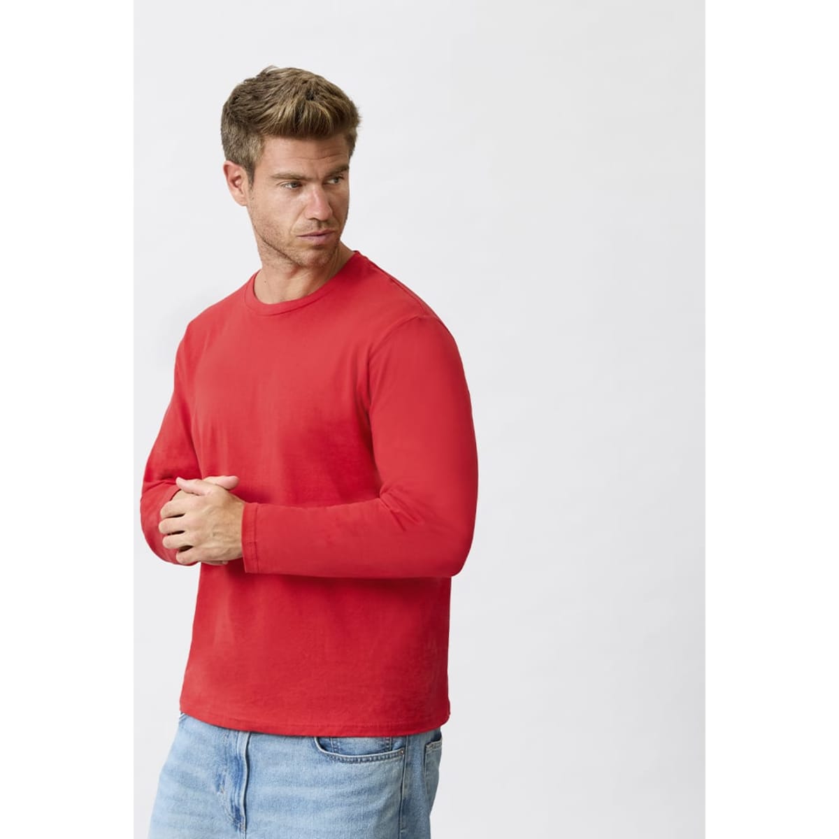 A red long-sleeve T-shirt displayed on a male model, featuring a logo on the front. The model is in a neutral pose.