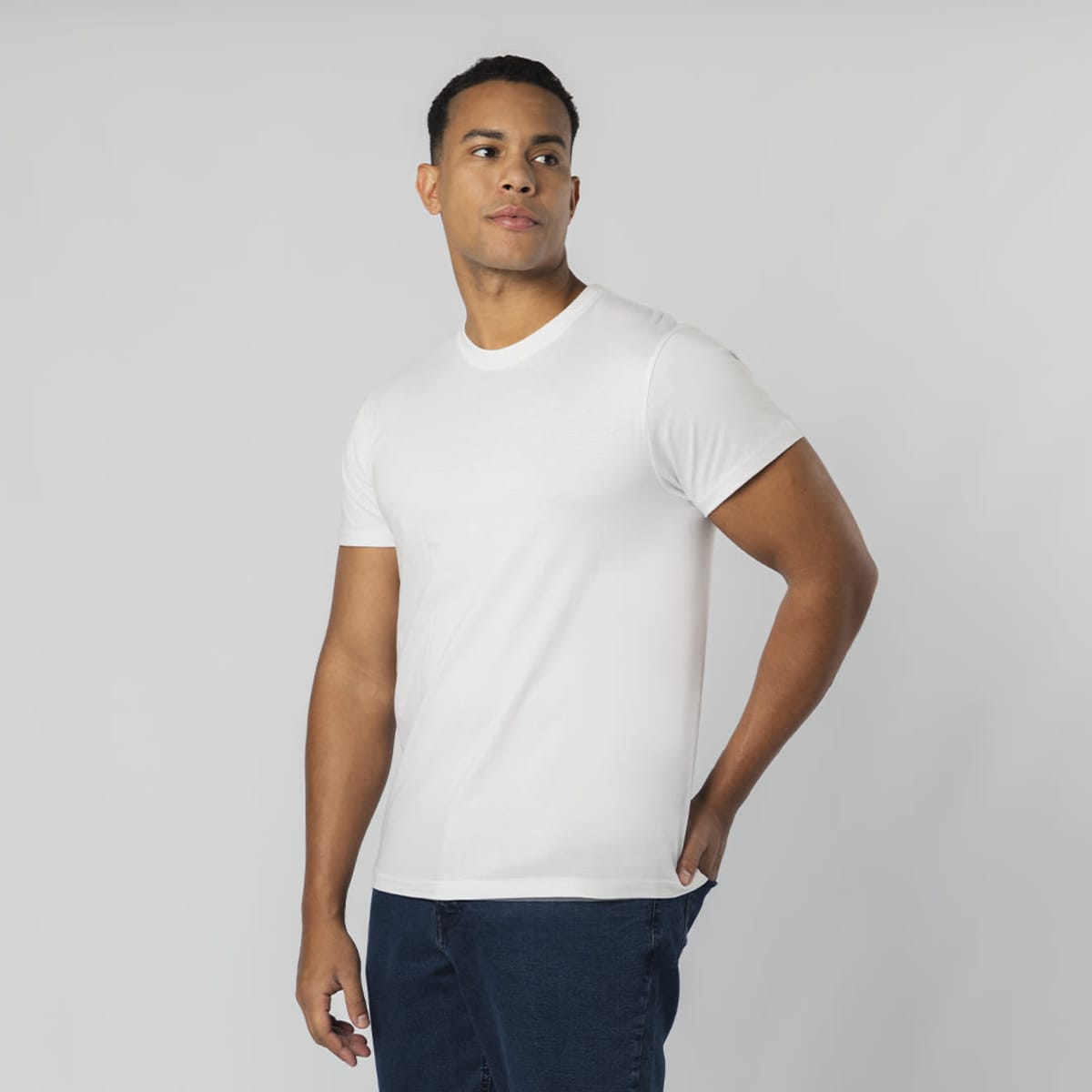 A white t-shirt is displayed, featuring a crew neckline and short sleeves, worn by a model against a neutral background.