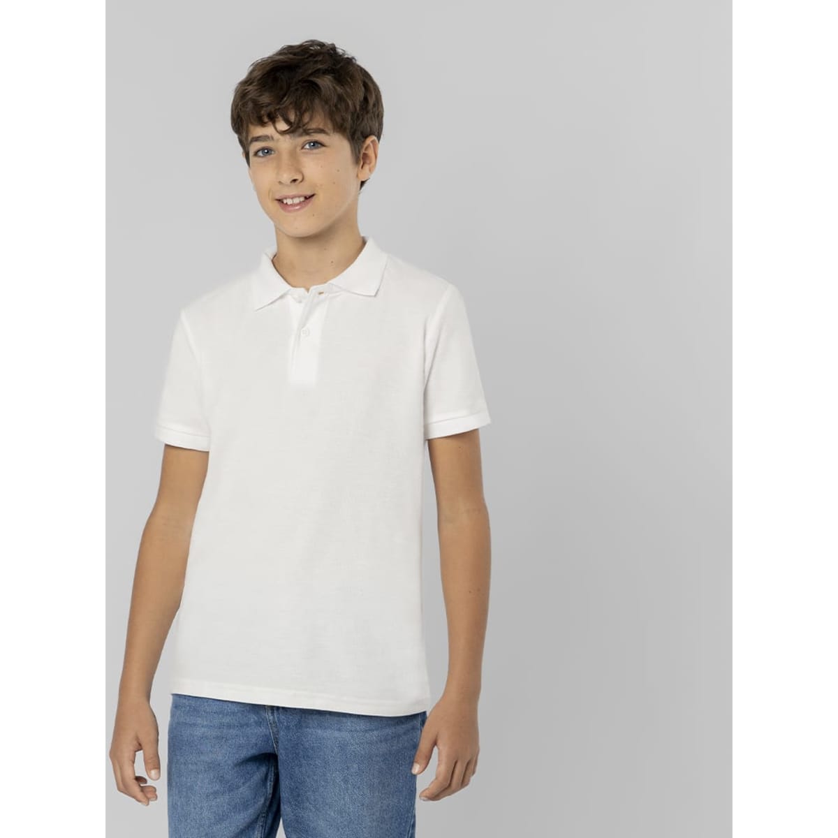A white polo shirt on a young model, featuring a collar and a simple design, styled with blue jeans.