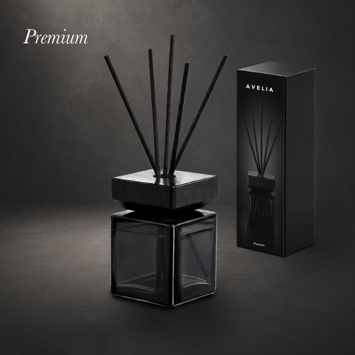 Avelia Aromatic Diffuser in a black square glass container with black reeds, next to its packaging.