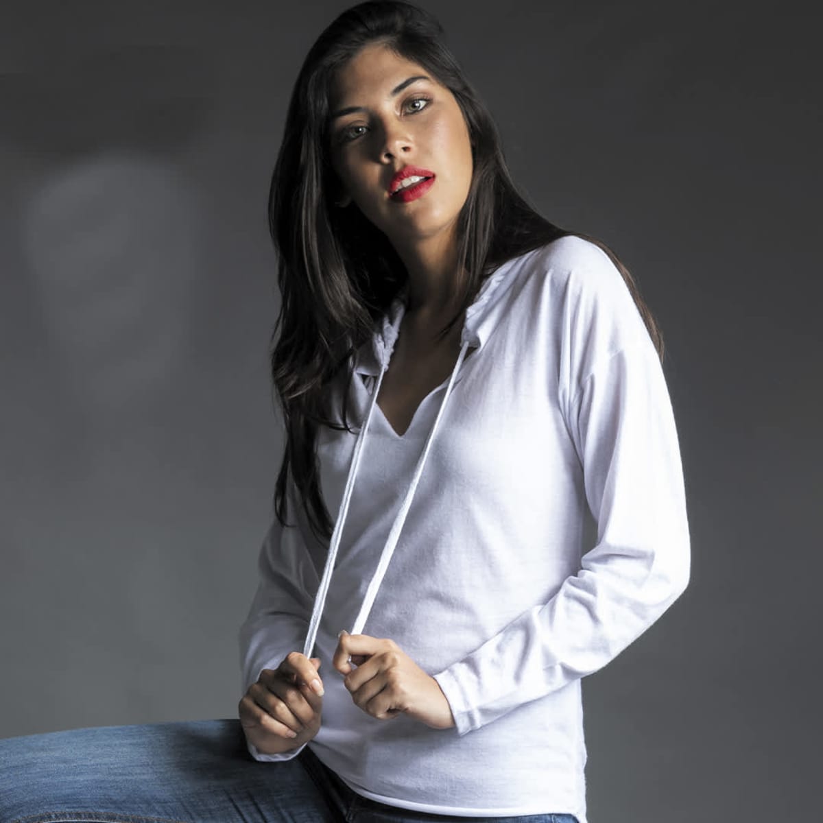 A white long-sleeve T-shirt with a V-neck and drawstring, worn by a model against a dark background.