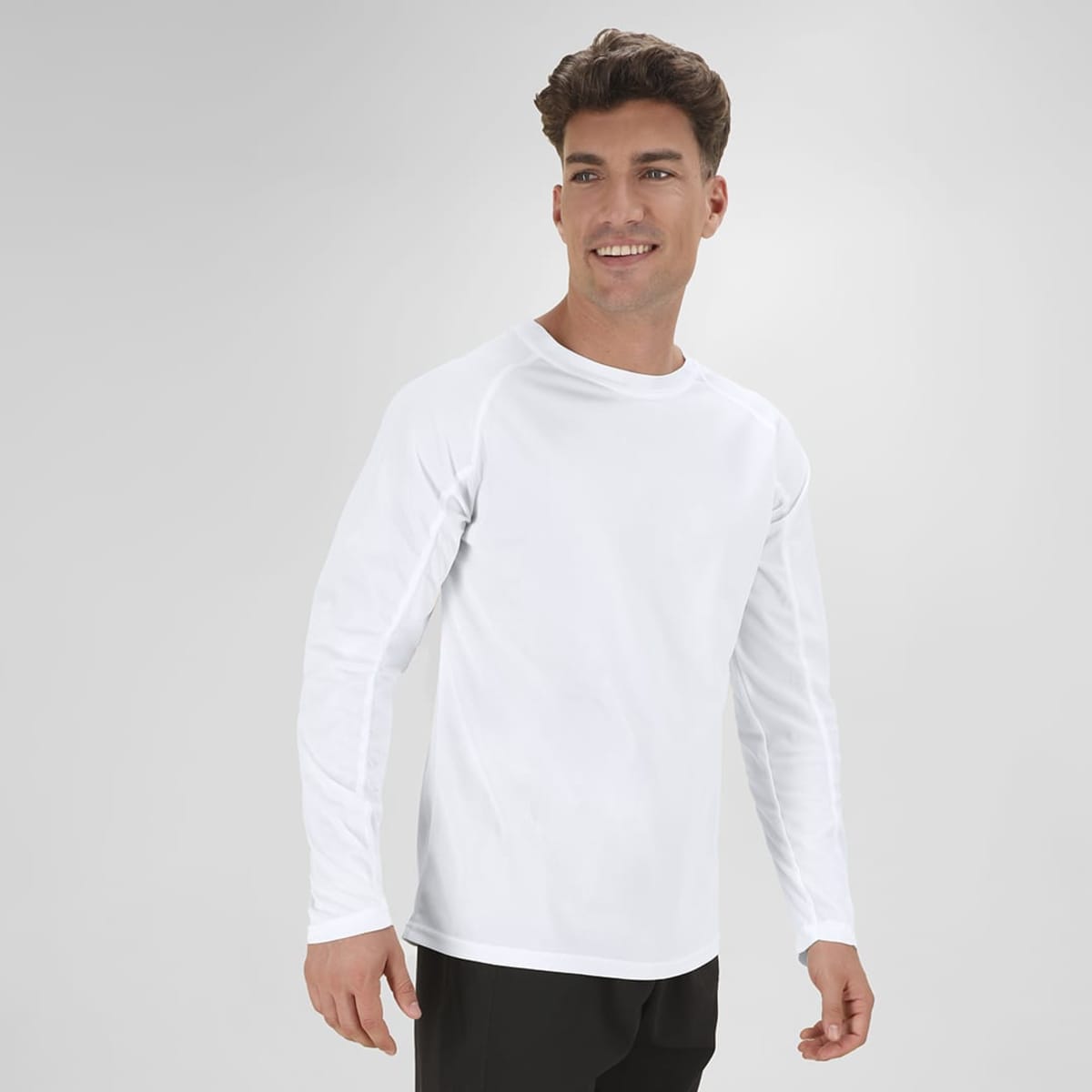 A white long-sleeve T-shirt on a model, featuring a simple design and a relaxed fit. It has a logo on it.