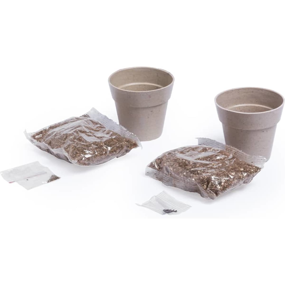 Two brown planting pots with two bags of soil and seed packets beside them.