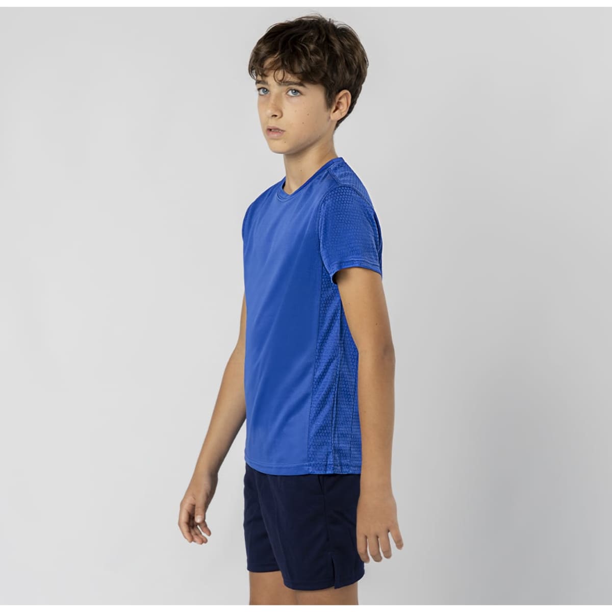A blue T-shirt featuring a textured design, displayed on a model wearing dark shorts. The shirt has a logo.