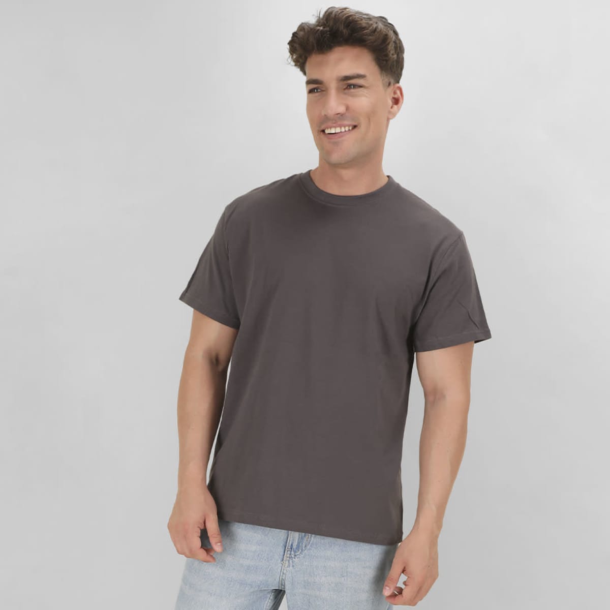 A grey t-shirt with a round neck and short sleeves, worn by a smiling male model against a neutral background.