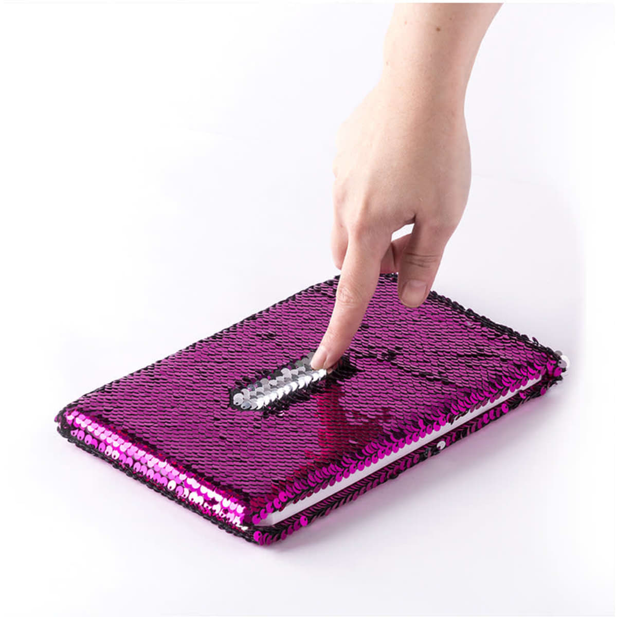 A pink and black sequin notepad with a sparkling surface, being touched by a hand. It features a logo.