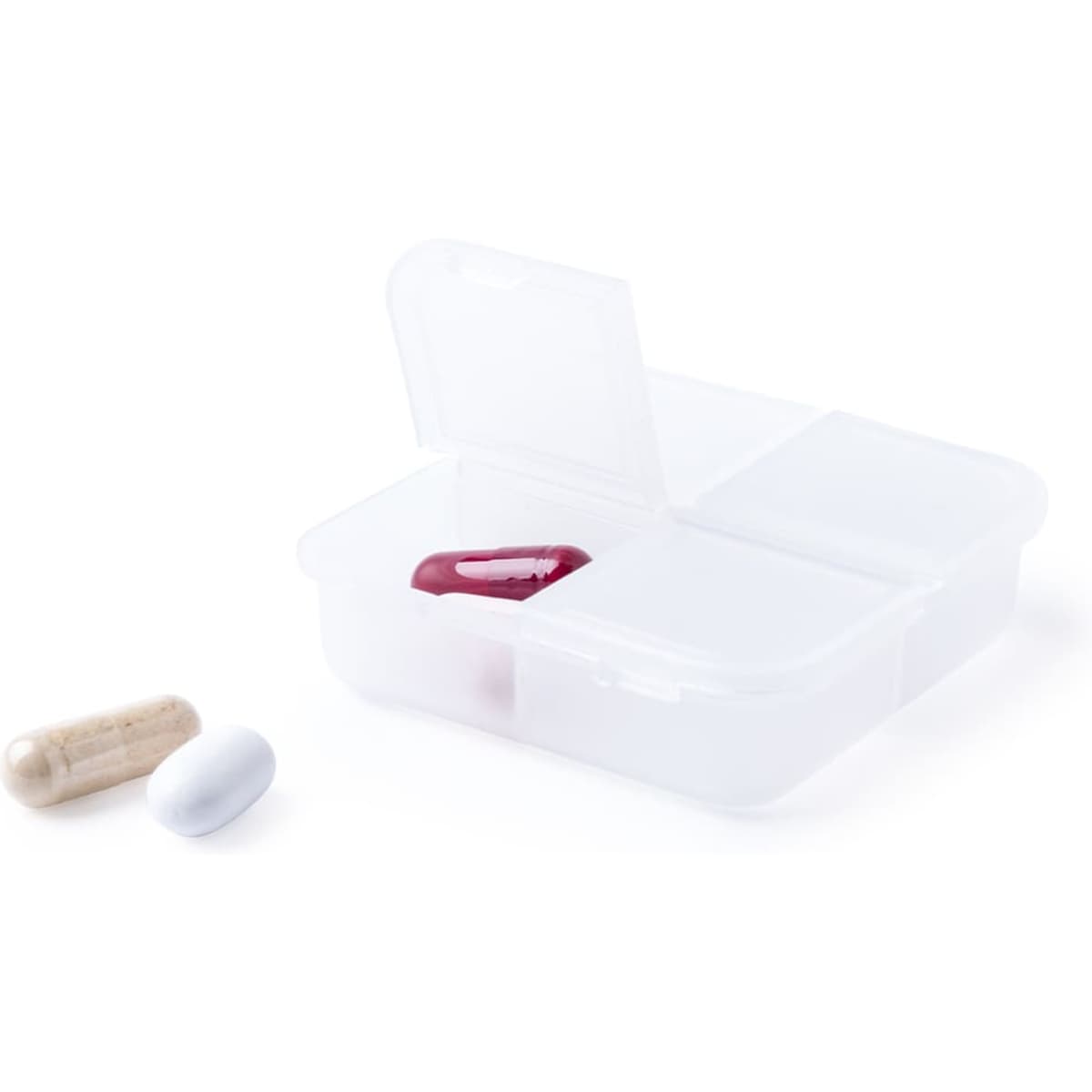 A clear pill organiser with four compartments, containing a red capsule, a white capsule, and a beige capsule.