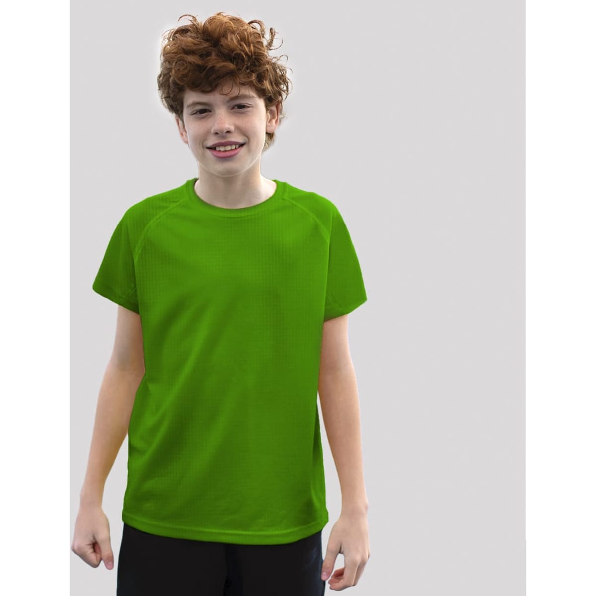 A young boy wearing a vibrant green dynamic T-shirt, smiling against a plain grey background.