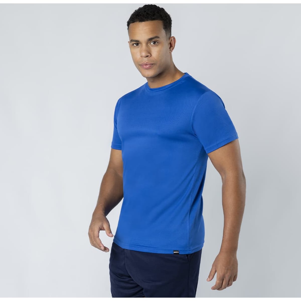 A blue Markus T-Shirt displayed by a model, featuring short sleeves and a logo on the bottom.