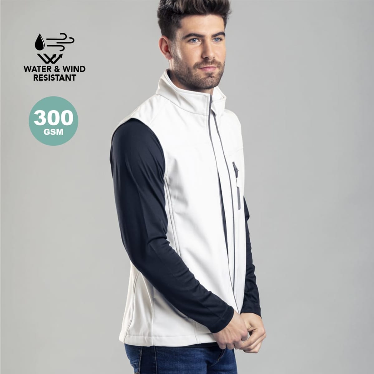 A man wearing a white and black water and wind resistant vest, featuring a zip and a logo on the chest.