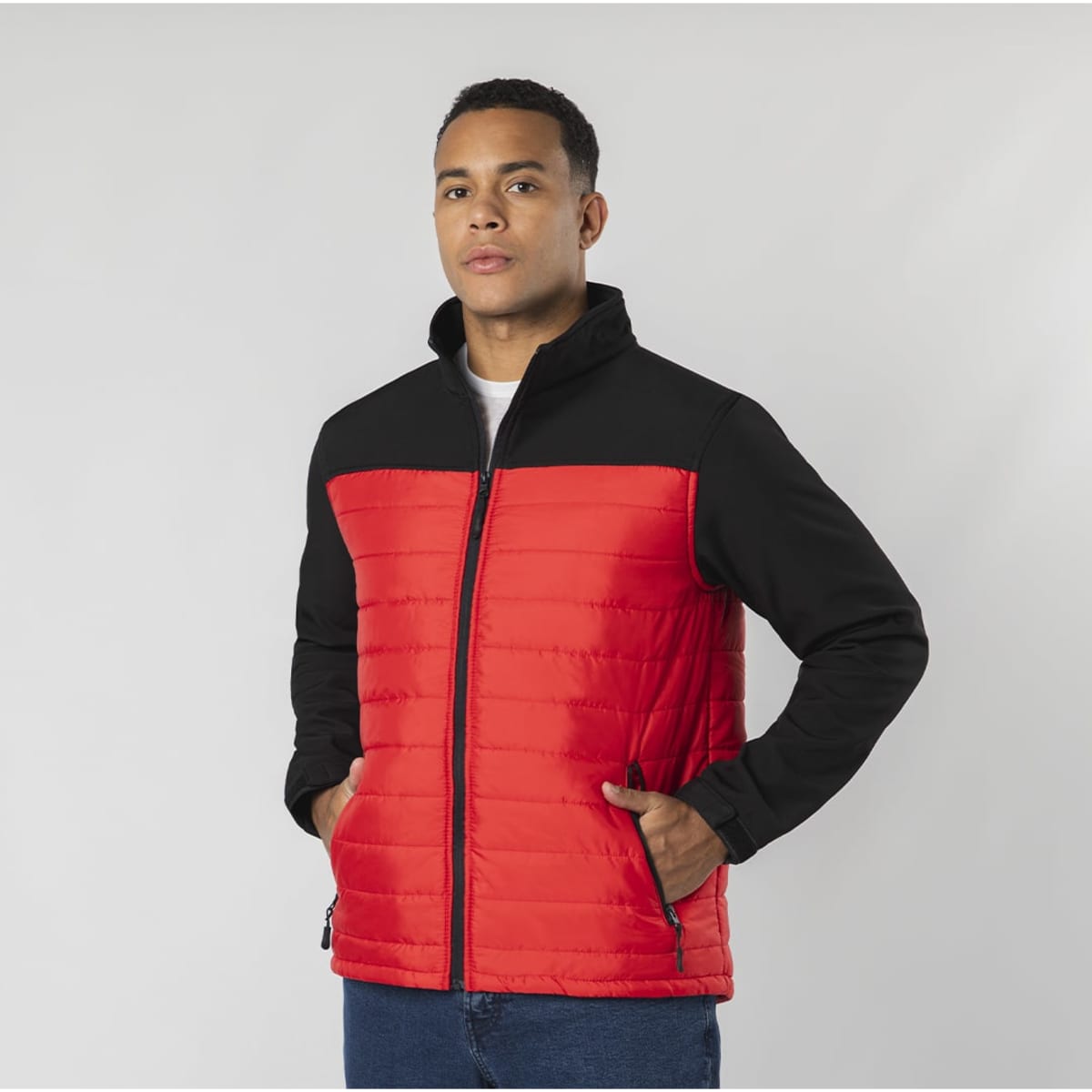 A red and black soft shell jacket with a zip and two side pockets, featuring a branding logo.
