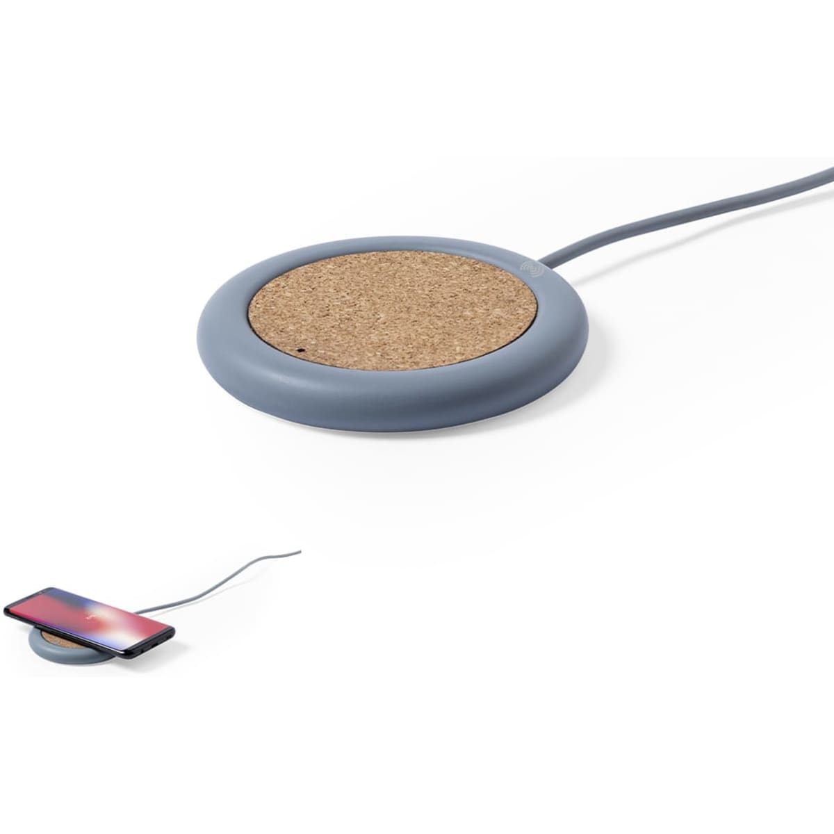 A wireless charger with a grey silicone base and a cork charging surface, accompanied by a smartphone on the side.