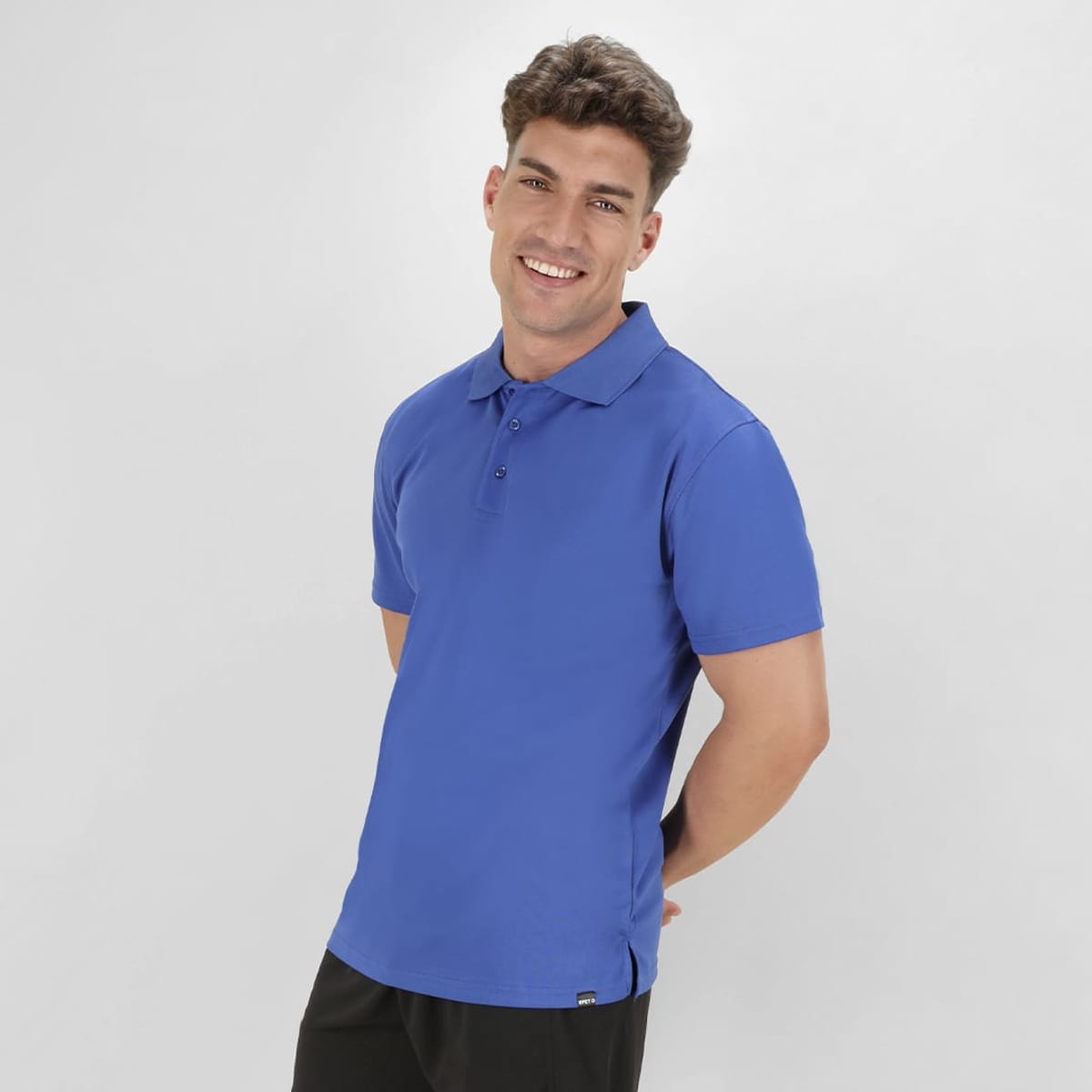 A blue polo shirt featuring a collar and short sleeves, displayed on a model with a confident smile.