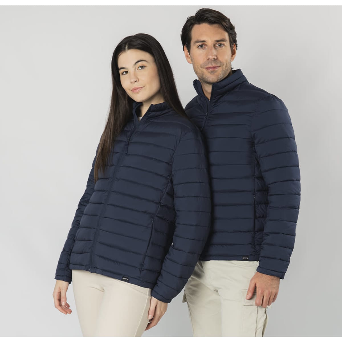 A navy puffer jacket featured on two models, one male and one female, standing side by side.
