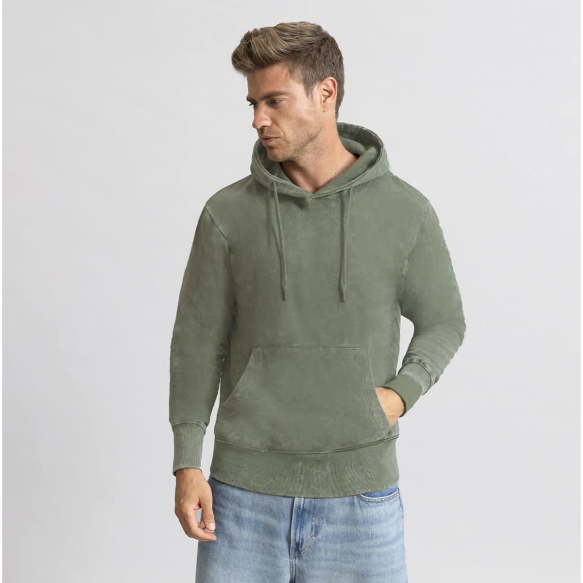 A green hoodie with a front pocket and drawstring, worn by a model against a neutral background.