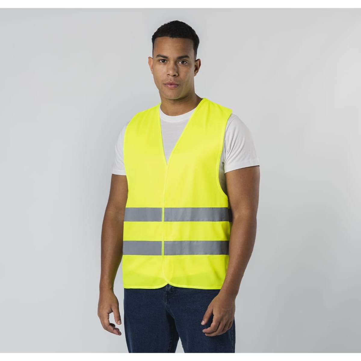 A high-visibility safety vest in bright yellow with reflective stripes, worn by a model.