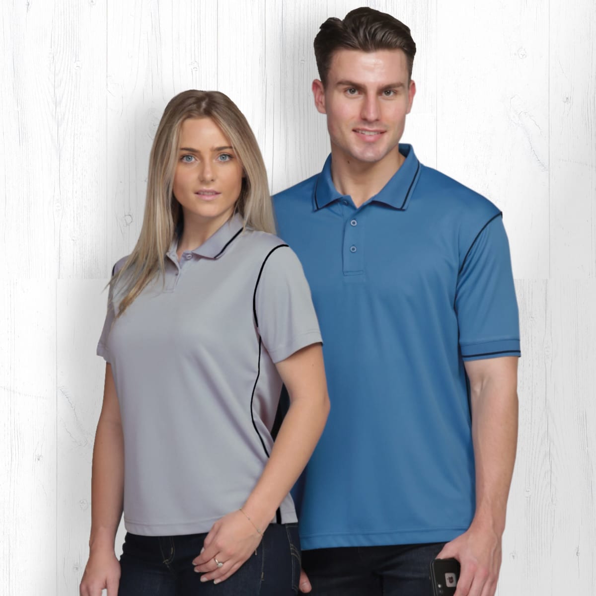 A women's grey polo shirt with black accents showcased alongside a men's blue polo shirt. Both feature a logo.
