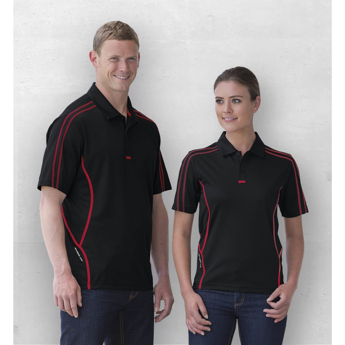 A black polo shirt featuring red detailing, displayed on a male and a female model. The shirt has a logo.